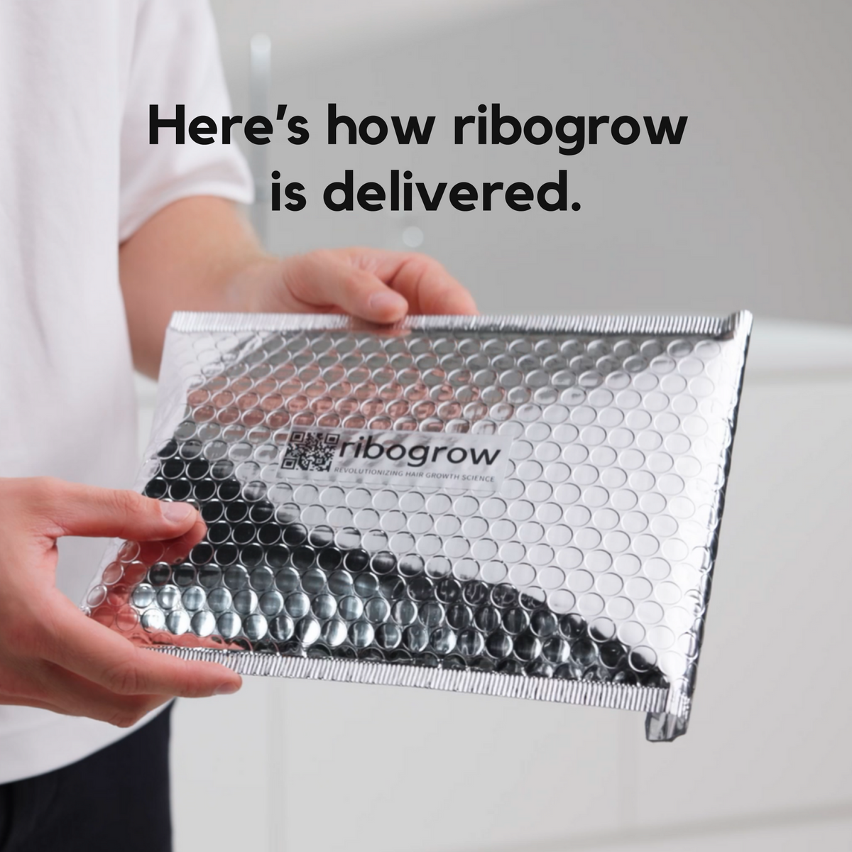ribogrow hair booster tonic packaging shown being held in protective padded shipping envelope, featuring ribogrow branding and secure packaging designed to protect the glass bottle during delivery and ensure safe arrival to the customer.