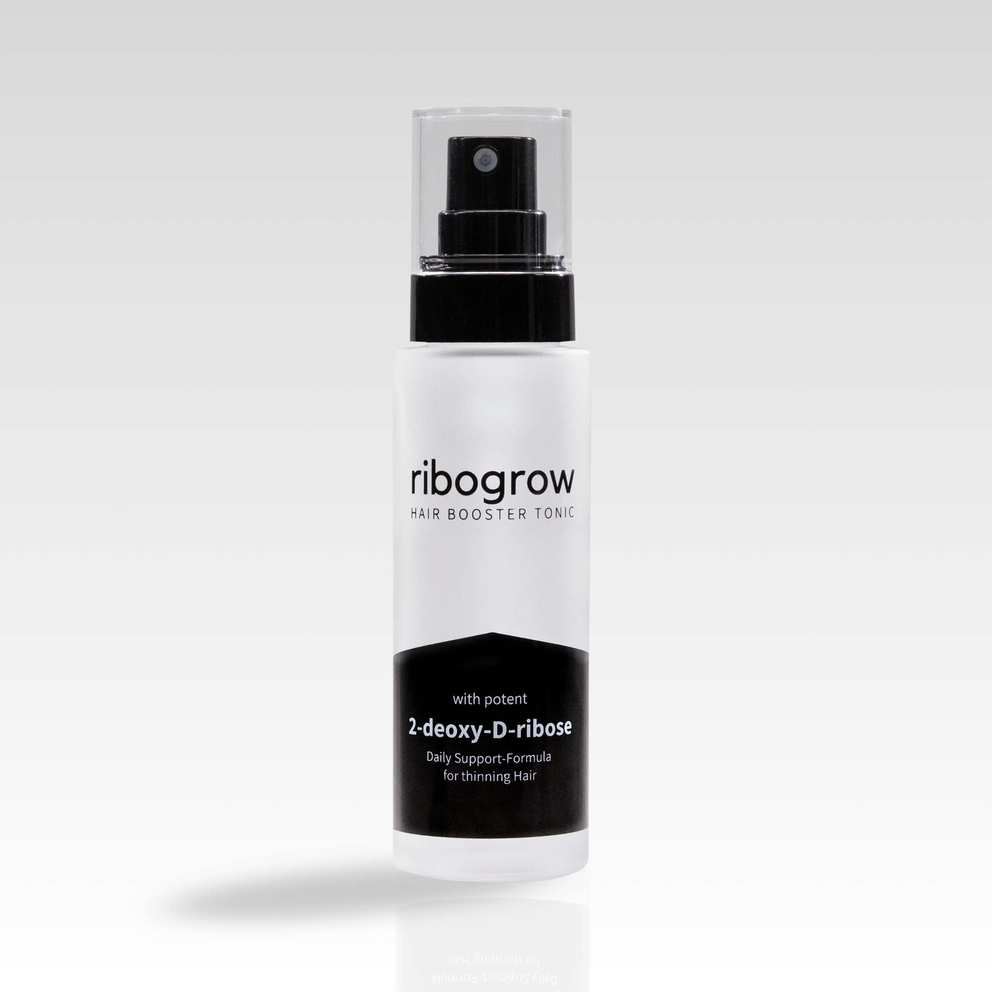 Einzelne Flasche ribogrow Hair Booster Tonic aus mattem Glas mit schwarzem Sprühkopf und transparenter Kappe, auf hellem, weich verlaufendem Hintergrund stehend.
